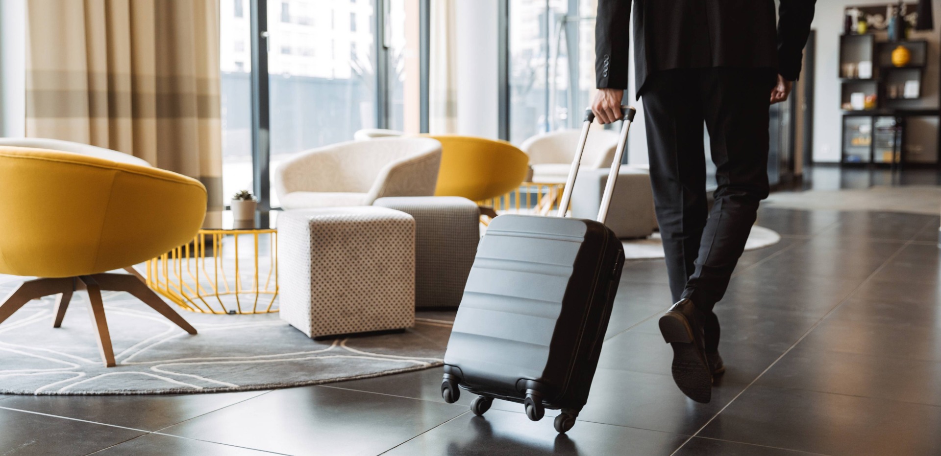 Person läuft mit Koffer durch eine Hotellobby